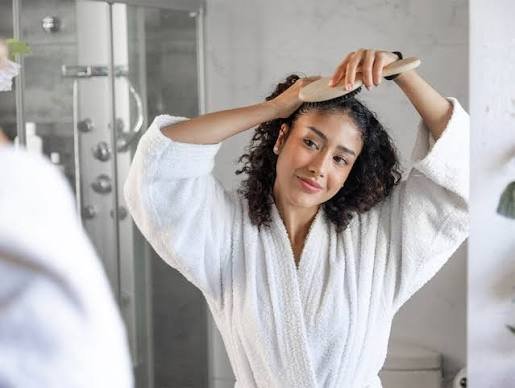Persona con cabello rizado natural y definido en una imagen dedicada al cuidado capilar en clima tropical.